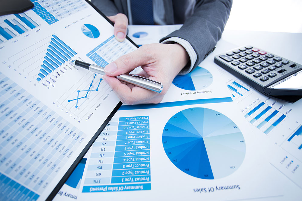 A man points with a pen in his hand to a business report